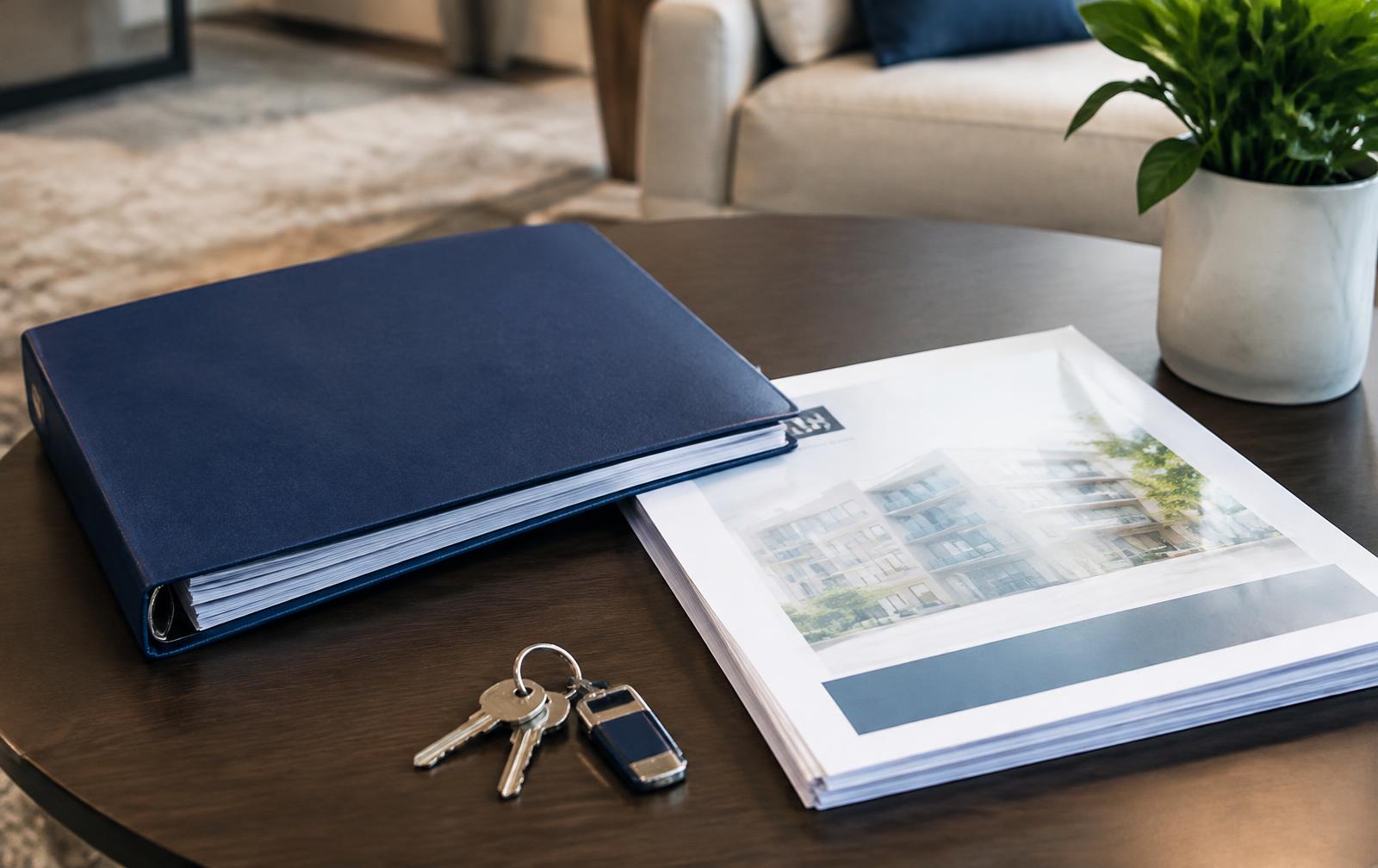 HOA budget binder and reserve study with condo keys on a lobby table