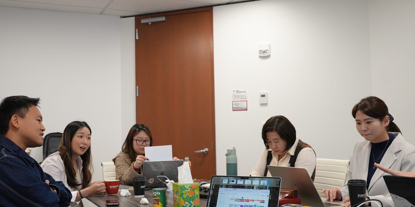 Maggie Sun Real Estate team in a client strategy meeting at the Bellevue office