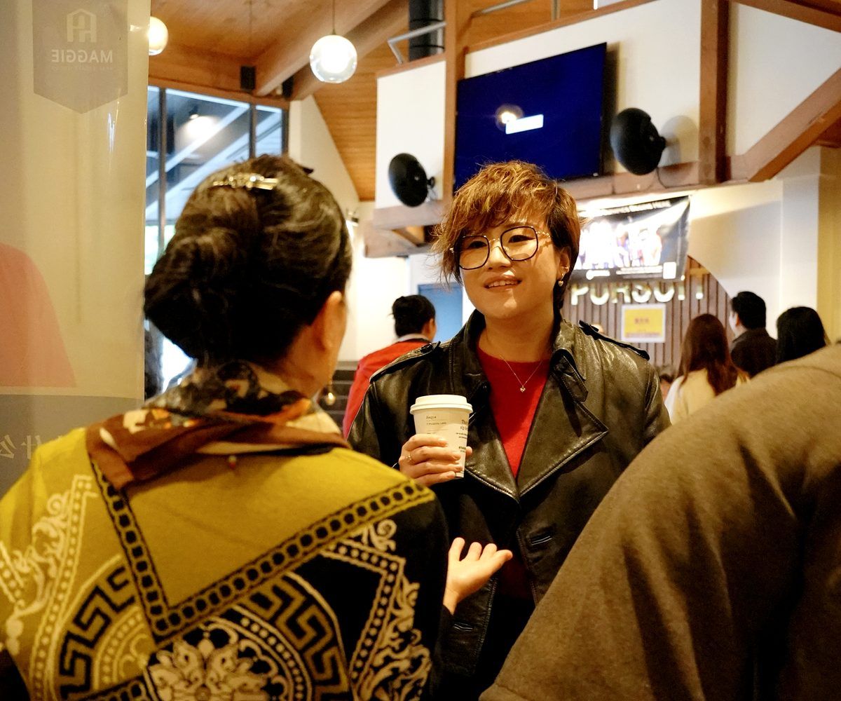 Maggie Sun speaking with clients at a Bellevue community event